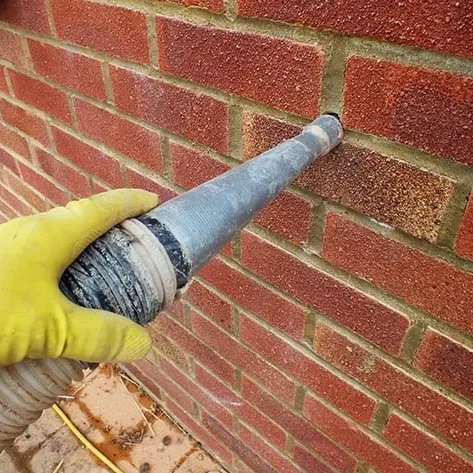 retrofit injecting material into a gap in a brick wall.
